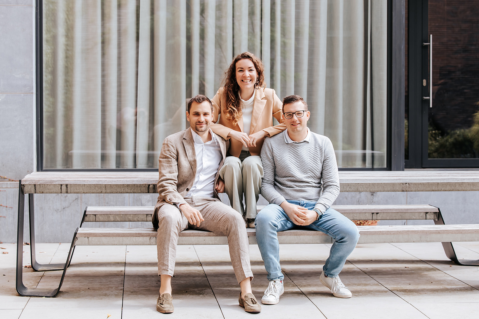 Drie medewerkers van Architime zitten samen op de bank