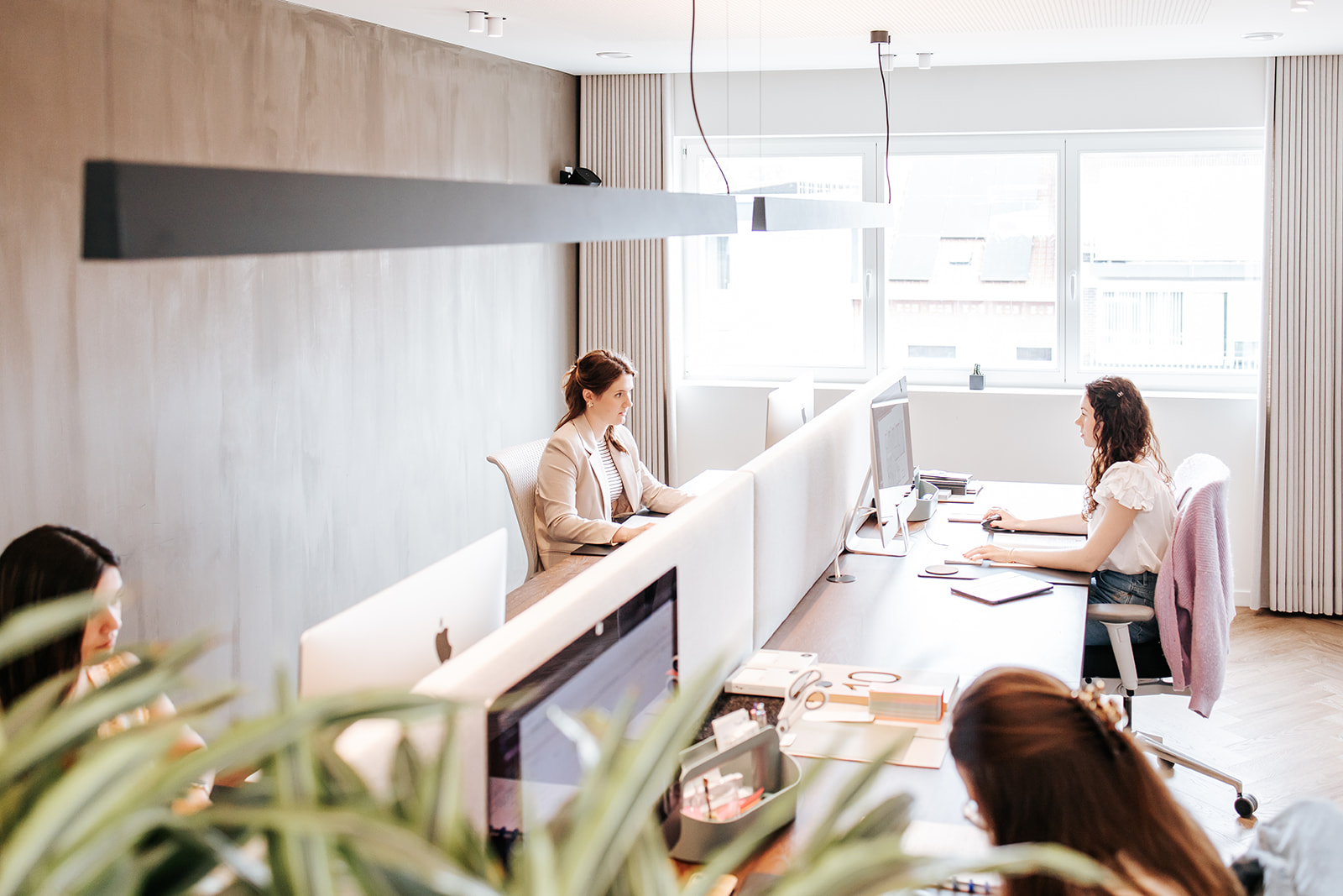 medewerkers bij Architime aan het werk aan hun bureau